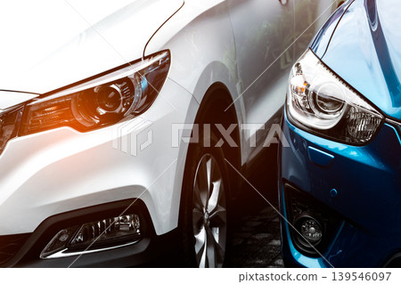 Closeup of blue and white SUV headlamp light parked at parking lot in hotel or shopping mall, modern automotive design. Electric or hybrid technology, car rental service and premium vehicle industry. 139546097