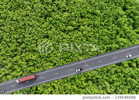 Aerial top view of car and truck driving on highway road in green forest. Sustainable transport. Drone view of hydrogen energy truck and electric vehicle driving on asphalt road through green forest. Aerial top view of car and truck driving on highway road in green forest. Sustainable transport. Drone view of hydrogen energy truck and electric vehicle driving on asphalt road through green forest. 139546098
