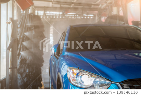 Blue SUV car washing by automatic car washing machine. Auto care. Car cleaning with high pressure water spray after clean by auto brush. Car cleaning before waxing service. Carwash service business. Blue SUV car washing by automatic car washing machine. Auto care. Car cleaning with high pressure water spray after clean by auto brush. Car cleaning before waxing service. Carwash service business. 139546110