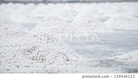 Sea salt farm. Pile of brine salt. Raw material of salt industrial. Sodium Chloride mineral. Evaporation and crystallization of sea water. White salt harvesting. Agriculture industry. Traditional farm 139546123