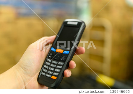 Hand holding a handheld terminal Hand holding a handheld terminal 139546665