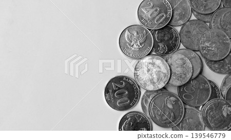 A collection of Indonesian rupiah coins scattered in black and white. 139546779