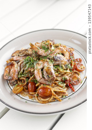 shrimp and tomato diavolo spicy spaghetti on white table at outdoor restaurant in italy shrimp and tomato diavolo spicy spaghetti on white table at outdoor restaurant in italy 139547143