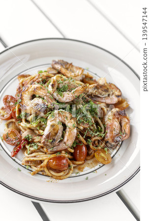 shrimp and tomato diavolo spicy spaghetti on white table at outdoor restaurant in italy 139547144