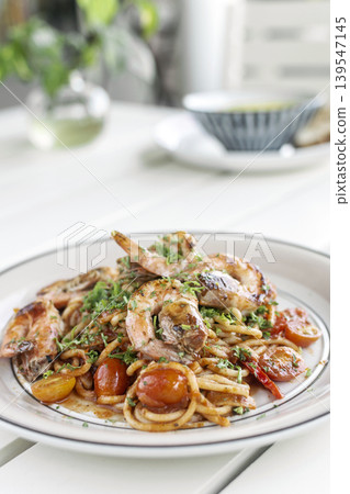 shrimp and tomato diavolo spicy spaghetti on white table at outdoor restaurant in italy 139547145