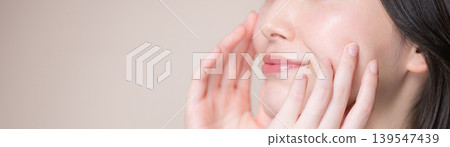 一位面帶微笑、肌膚晶瑩剔透的女子，在米色背景的襯托下，抬頭望向天空，但臉部卻看不見。這是一張護膚和美容的圖片。 139547439