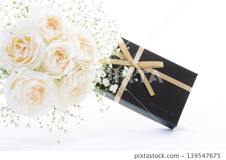 A bouquet of pale-colored roses in a gift box with a gold ribbon. A bouquet of pale-colored roses in a gift box with a gold ribbon. 139547675