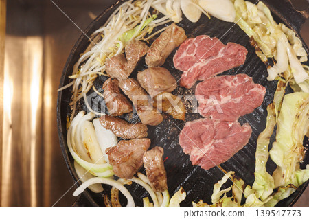生羊肉放在成吉思汗烤架上烤製。 139547773