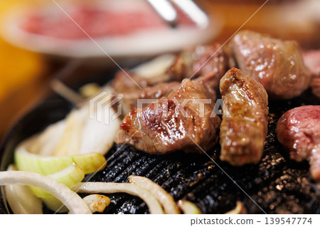 生羊肉放在成吉思汗烤架上烤製。 139547774