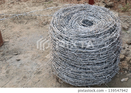 Real barbed wire on field for fence of garden Real barbed wire on field for fence of garden 139547942