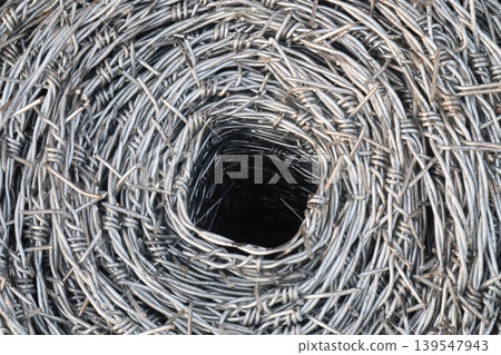 Real barbed wire on field for fence of garden Real barbed wire on field for fence of garden 139547943