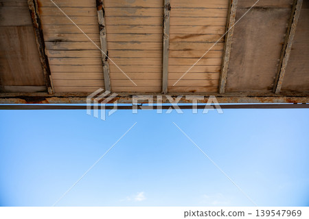 A decaying roof and a vast blue sky A decaying roof and a vast blue sky 139547969