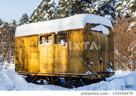 Abandoned, rusty construction trailer deep in a snowy northern forest. A weathered work hut, a stark symbol of forgotten times and harsh winter conditions at a remote site 139548479