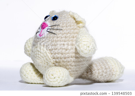 Knitted white cat on a white background Knitted white cat on a white background 139548503