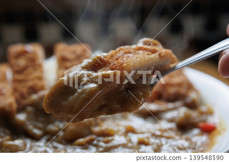 A piping hot chicken cutlet curry served on a spoon A piping hot chicken cutlet curry served on a spoon 139548590