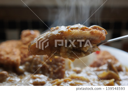 雞排咖哩飯盛在熱氣騰騰的湯匙上。 雞排咖哩飯盛在熱氣騰騰的湯匙上。 139548593