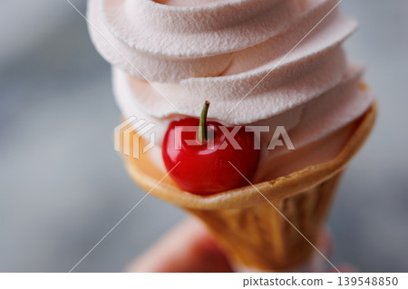Soft serve ice cream topped with fresh cherries 139548850