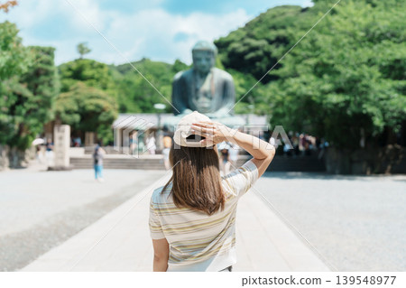 Woman tourist Visiting in Kamakura, Kanagawa prefecture , Japan. happy Traveler sightseeing the Great Buddha statue. Landmark and popular for tourists attraction near Tokyo. Travel and Vacation Woman tourist Visiting in Kamakura, Kanagawa prefecture , Japan. happy Traveler sightseeing the Great Buddha statue. Landmark and popular for tourists attraction near Tokyo. Travel and Vacation 139548977