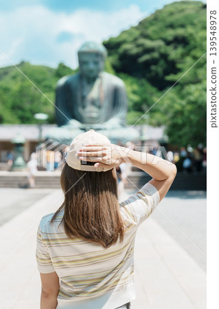 Woman tourist Visiting in Kamakura, Kanagawa prefecture , Japan. happy Traveler sightseeing the Great Buddha statue. Landmark and popular for tourists attraction near Tokyo. Travel and Vacation Woman tourist Visiting in Kamakura, Kanagawa prefecture , Japan. happy Traveler sightseeing the Great Buddha statue. Landmark and popular for tourists attraction near Tokyo. Travel and Vacation 139548978