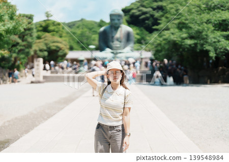Woman tourist Visiting in Kamakura, Kanagawa prefecture , Japan. happy Traveler sightseeing the Great Buddha statue. Landmark and popular for tourists attraction near Tokyo. Travel and Vacation Woman tourist Visiting in Kamakura, Kanagawa prefecture , Japan. happy Traveler sightseeing the Great Buddha statue. Landmark and popular for tourists attraction near Tokyo. Travel and Vacation 139548984
