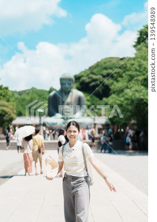 Woman tourist Visiting in Kamakura, Kanagawa prefecture , Japan. happy Traveler sightseeing the Great Buddha statue. Landmark and popular for tourists attraction near Tokyo. Travel and Vacation Woman tourist Visiting in Kamakura, Kanagawa prefecture , Japan. happy Traveler sightseeing the Great Buddha statue. Landmark and popular for tourists attraction near Tokyo. Travel and Vacation 139548989