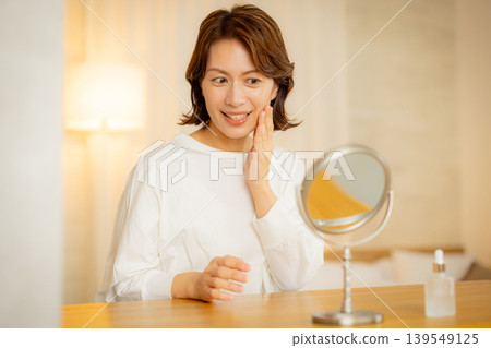 一位女性夜裡在臥室裡擔心自己的皮膚狀況。 一位女性夜裡在臥室裡擔心自己的皮膚狀況。 139549125