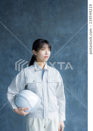 A woman in work clothes checking something A woman in work clothes checking something 139549219