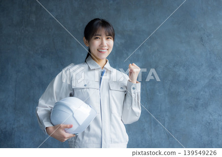 一名身穿工作服的女子正在檢查某物。 一名身穿工作服的女子正在檢查某物。 139549226