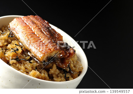 一張迷你鰻魚飯碗的照片,單獨擺放在黑色背景前。 一張迷你鰻魚飯碗的照片,單獨擺放在黑色背景前。 139549557