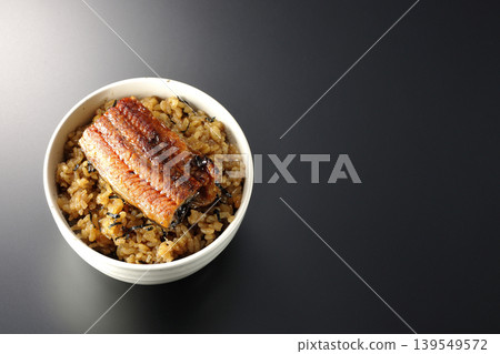 一張迷你鰻魚飯碗的照片,單獨擺放在黑色背景前。 一張迷你鰻魚飯碗的照片,單獨擺放在黑色背景前。 139549572