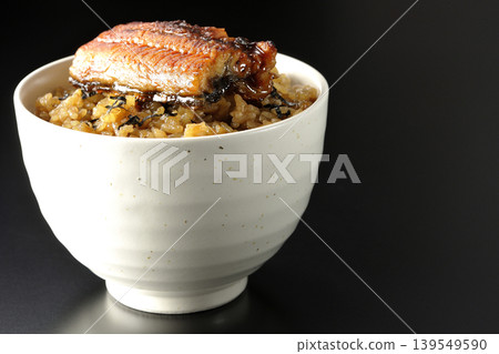 一張迷你鰻魚飯碗的照片,單獨擺放在黑色背景前。 一張迷你鰻魚飯碗的照片,單獨擺放在黑色背景前。 139549590