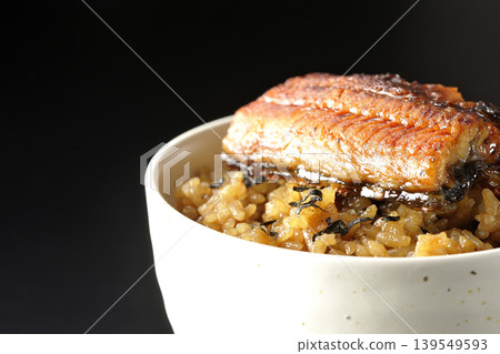 一張迷你鰻魚飯碗的照片,單獨擺放在黑色背景前。 一張迷你鰻魚飯碗的照片,單獨擺放在黑色背景前。 139549593