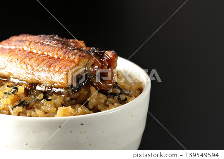 一張迷你鰻魚飯碗的照片,單獨擺放在黑色背景前。 一張迷你鰻魚飯碗的照片,單獨擺放在黑色背景前。 139549594