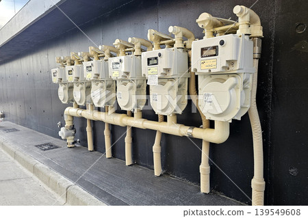 Residential gas meters installed in a row on the exterior wall of an apartment building in Japan. Residential gas meters installed in a row on the exterior wall of an apartment building in Japan. 139549608