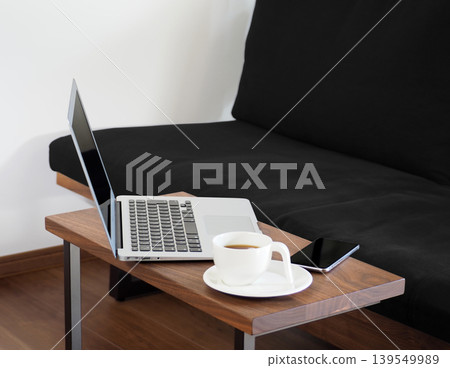 在家工作,在客廳裡用筆記型電腦工作的圖片。 在家工作,在客廳裡用筆記型電腦工作的圖片。 139549989