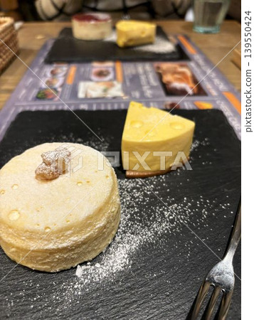Enjoying a cheesecake plate at a cafe. Enjoying a cheesecake plate at a cafe. 139550424