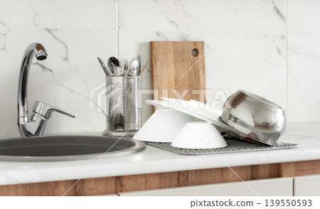 Clean dishes drying near kitchen sink Clean dishes drying near kitchen sink 139550593