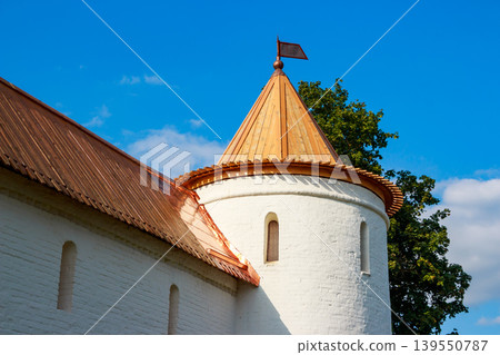 Classic white fort tower, topped with a brilliant copper conical roof and pennant, stark against a crisp blue sky Classic white fort tower, topped with a brilliant copper conical roof and pennant, stark against a crisp blue sky 139550787