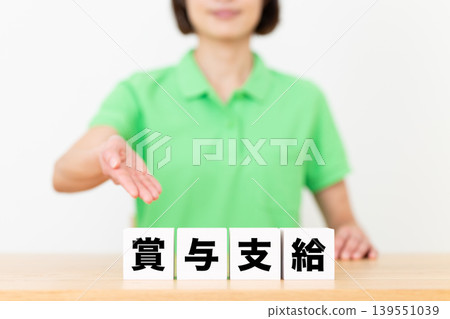 Bonus payment block and middle-aged female care staff Bonus payment block and middle-aged female care staff 139551039