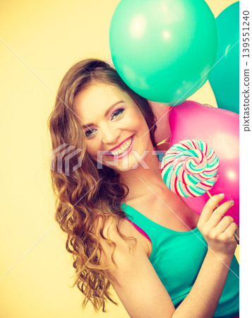Woman with colorful balloons and lollipop Woman with colorful balloons and lollipop 139551240