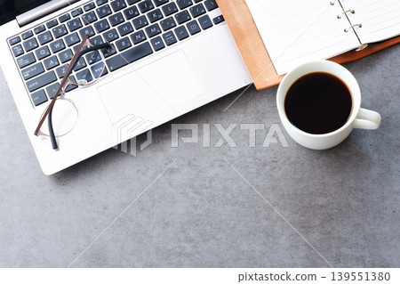 An image of someone working at a desk with a laptop and a personal organizer while drinking freshly brewed delicious coffee An image of someone working at a desk with a laptop and a personal organizer while drinking freshly brewed delicious coffee 139551380