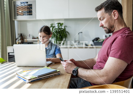 Family balancing work and education at home with father and child together. 139551401