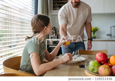 Father handing glass of juice to diabetic daughter. 139551436