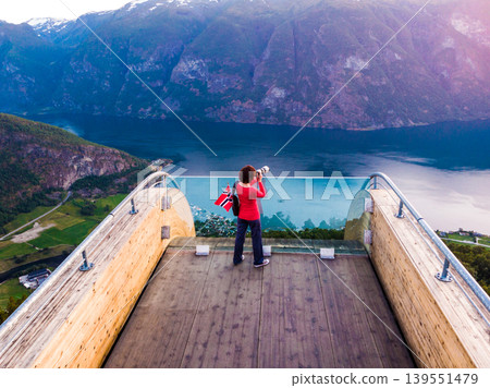 Tourist enjoying fjord view on Stegastein viewpoint Norway Tourist enjoying fjord view on Stegastein viewpoint Norway 139551479