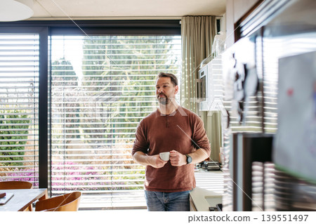 Man preparing coffee in modern kitchen at home. Man preparing coffee in modern kitchen at home. 139551497