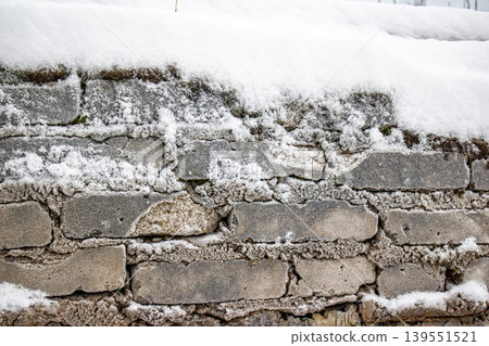 Aged brick wall texture, rugged and winter-worn, beautifully dusted with crisp white snow and frost. Perfect chilly background Aged brick wall texture, rugged and winter-worn, beautifully dusted with crisp white snow and frost. Perfect chilly background 139551521