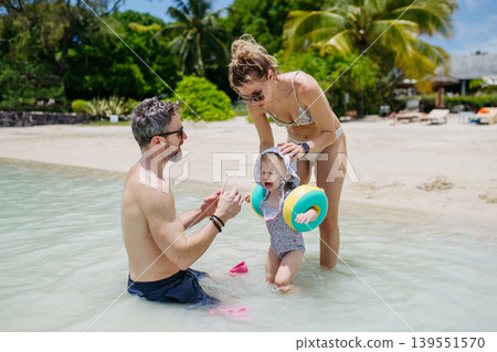 Family enjoying tropical beach vacation at luxury resort. Family enjoying tropical beach vacation at luxury resort. 139551570
