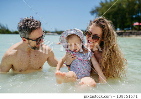 Family enjoying tropical beach vacation at luxury resort. Family enjoying tropical beach vacation at luxury resort. 139551571