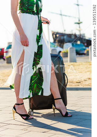 Woman with suitcae on city street Woman with suitcae on city street 139551592