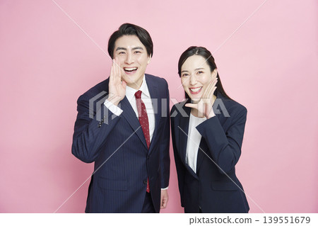 Businessmen and businesswomen cheering on the camera, looking directly at the camera. Businessmen and businesswomen cheering on the camera, looking directly at the camera. 139551679